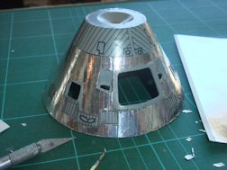 Apollo Command Module model with foil being applied